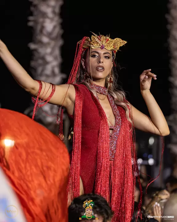 Performer in costume rosso con copricapo dorato durante la serata
