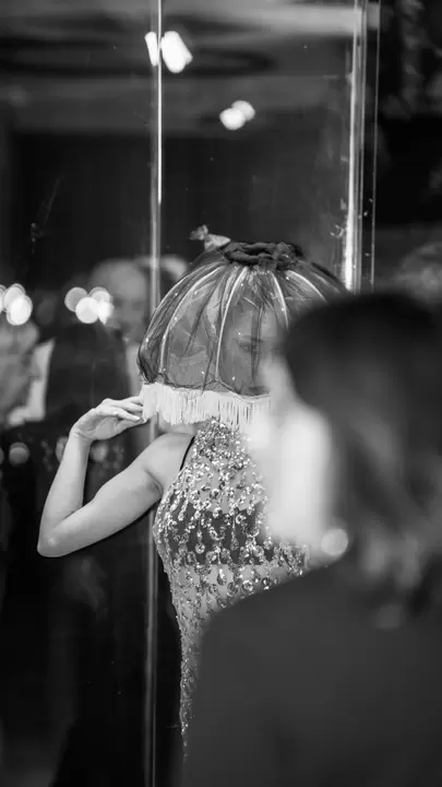 Performer con paralume di tulle e frange e abito di paillettes, in bianco e nero