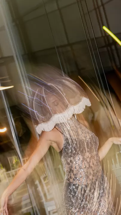 Performer con paralume di tulle che balla tra le luci in movimento
