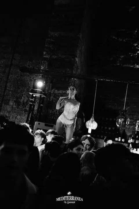 Performer con maschera di cristalli sopra il pubblico, in bianco e nero