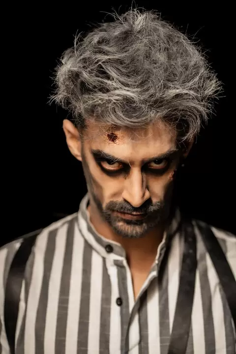 Personaggio con capelli argento e camicia a righe in stile Beetlejuice