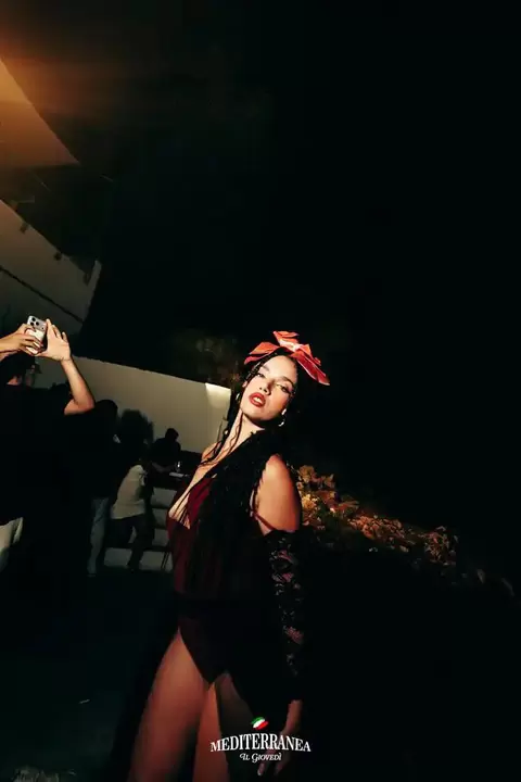 Performer con fiore rosso tra le trecce in posa durante la serata